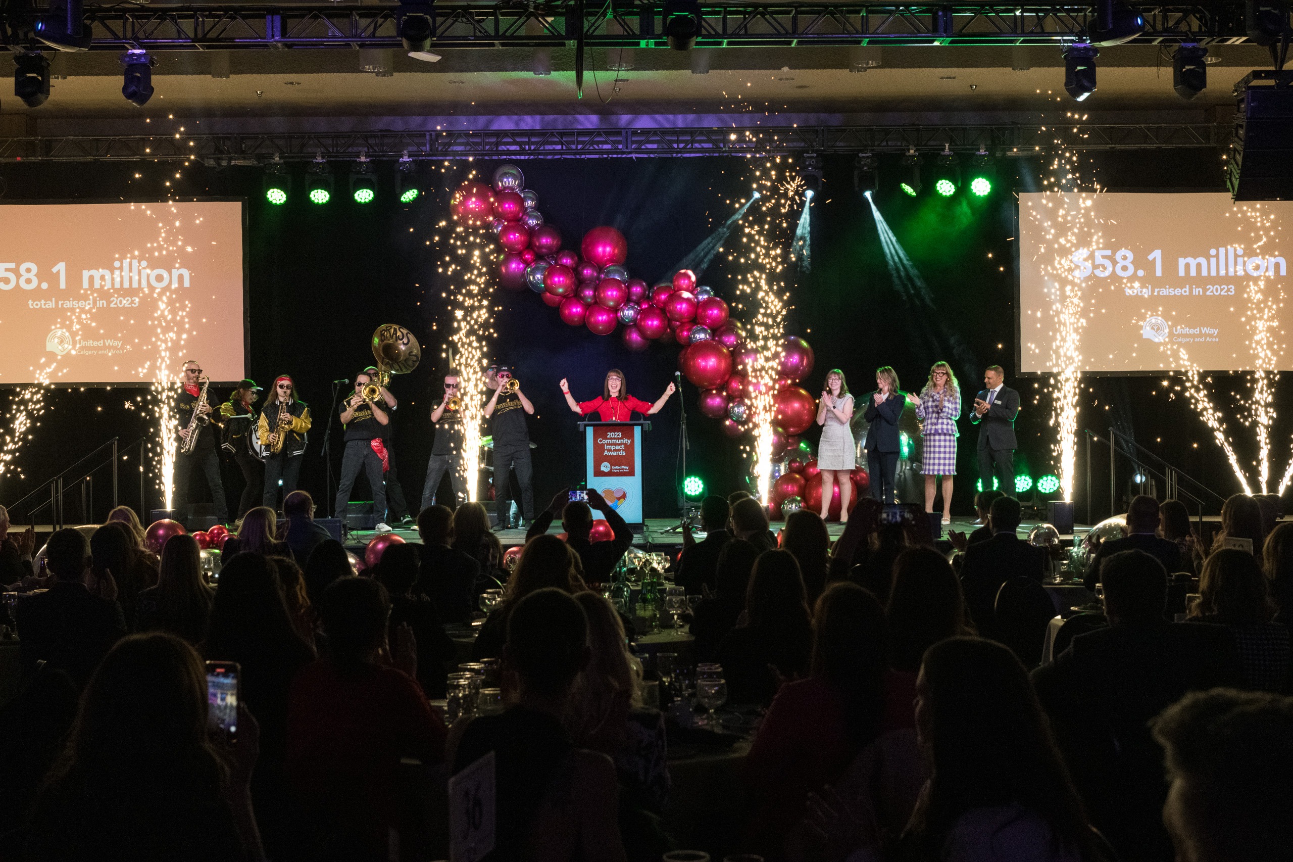 a stage with people excited to raise money for a charity