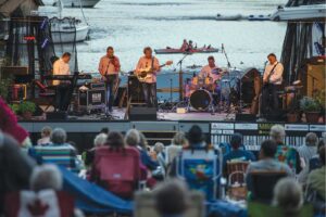 a band playing in front of a lake