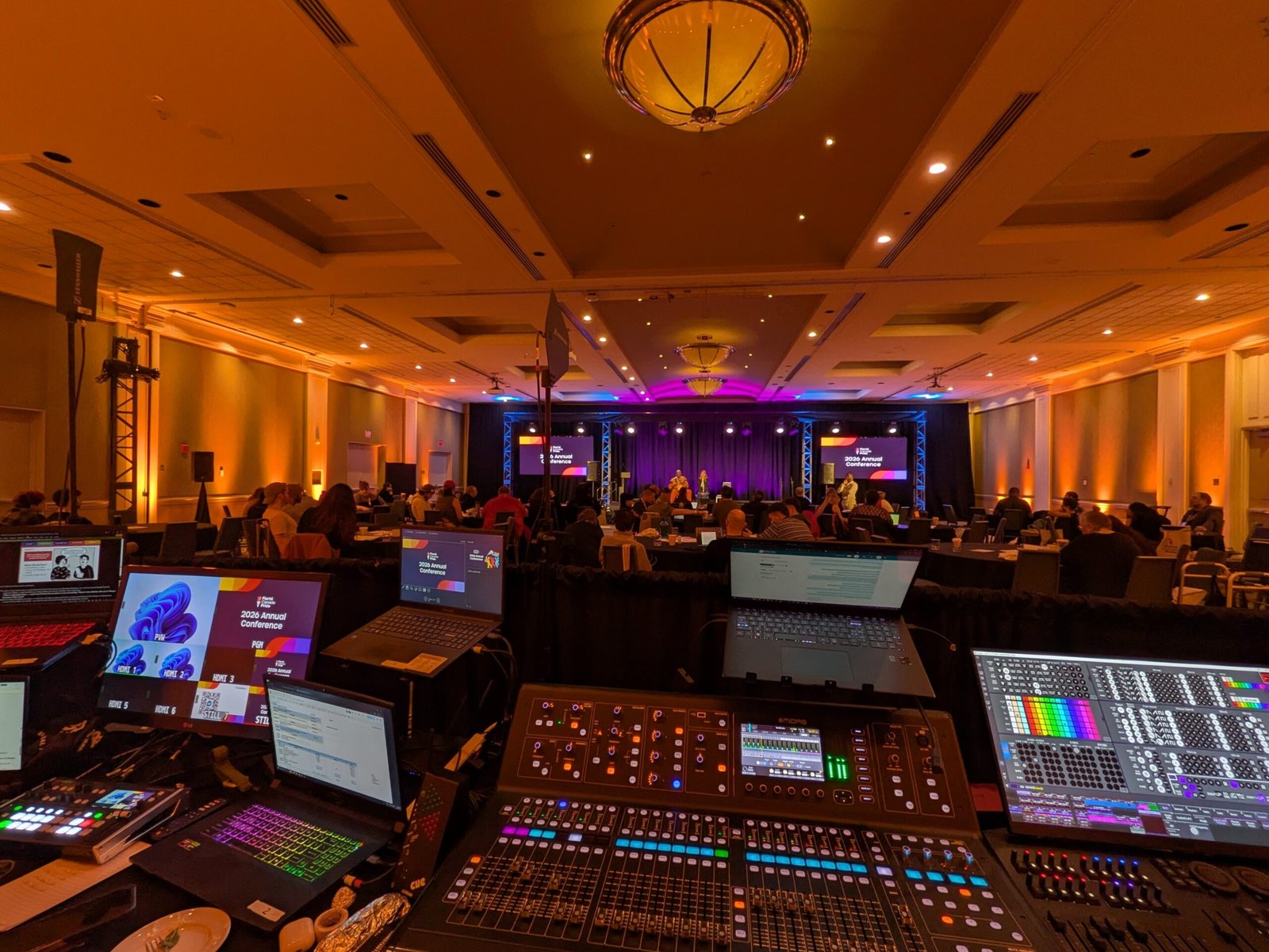 a ballroom with video screens and a tech area